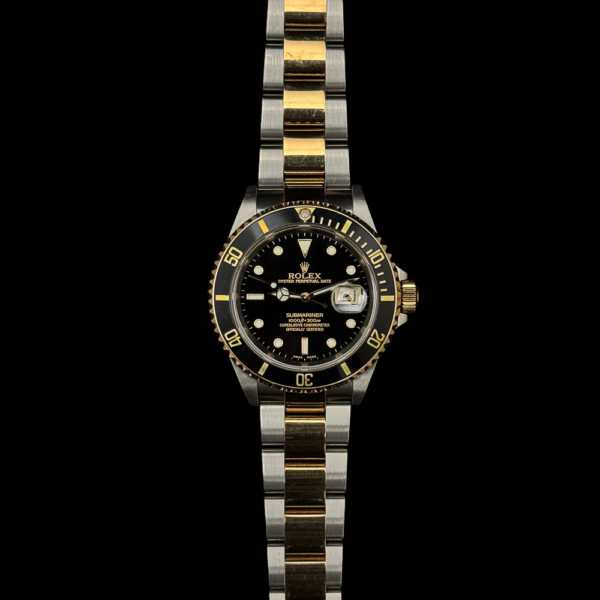 image of a 2002 Rolex Submariner 16613 two-tone watch with a black dial. The watch features a classic design with a stainless steel and yellow gold combination, showcasing a unidirectional rotating bezel and luminous hour markers. The black dial complements the gold and steel elements, creating a sleek and timeless aesthetic.